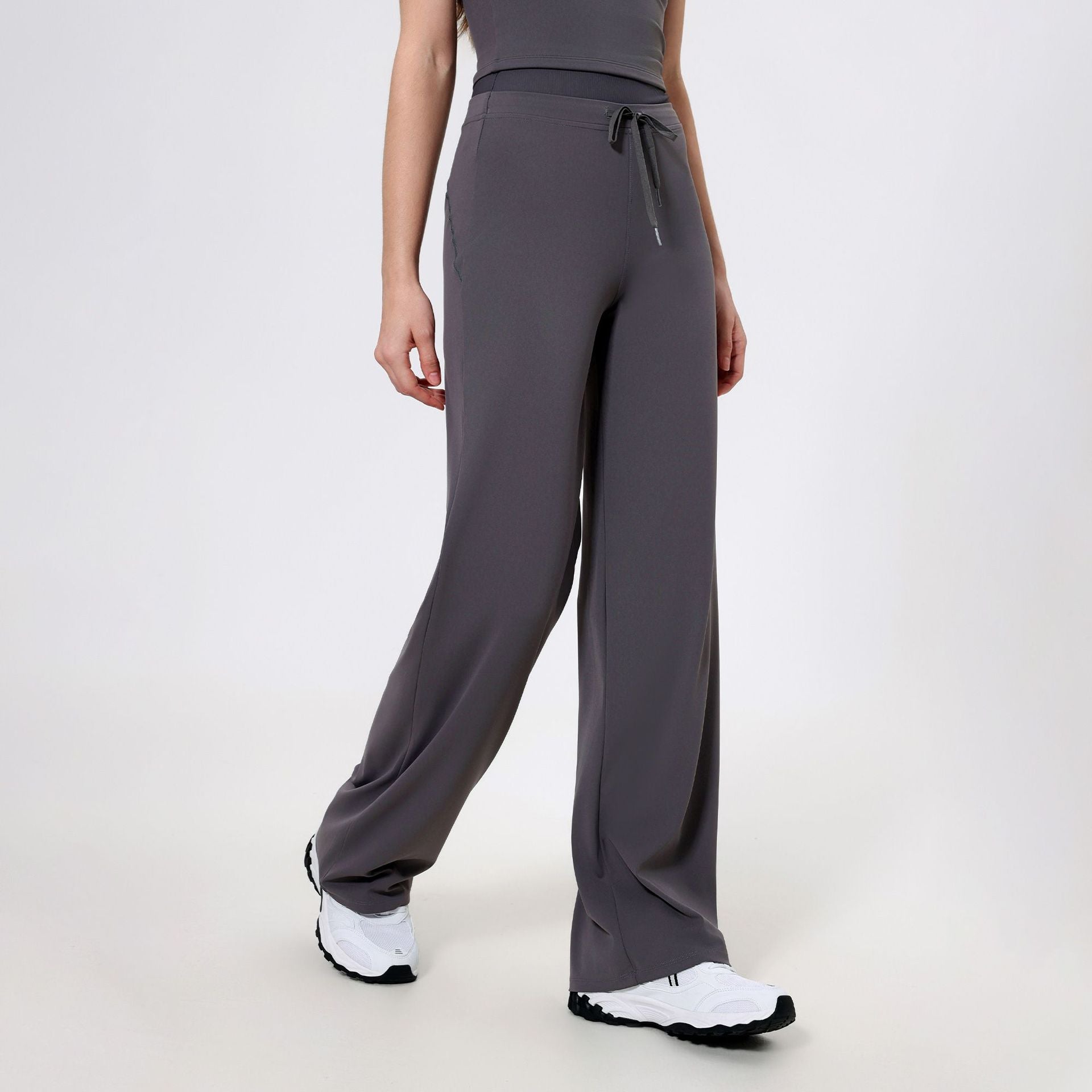 Gray wide-leg athletic pants with drawstring waist and white sneakers for stylish sports fashion