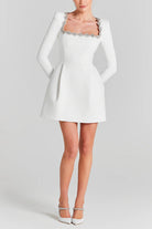 White long-sleeved mini dress with embellished square neckline for elegant fashion ملابس