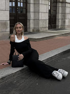 A person in a black off-shoulder outfit showcasing the Attractive Two Piece Vest Dress