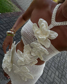 White crochet dress with floral appliqué, ideal for a stylish beach holiday fashion