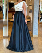 Elegant two-piece formal gown featuring a white top and black satin skirt in stylish fashion