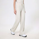 Cream-colored drawstring sweatpants with white sneakers for trendy fashion ملابس