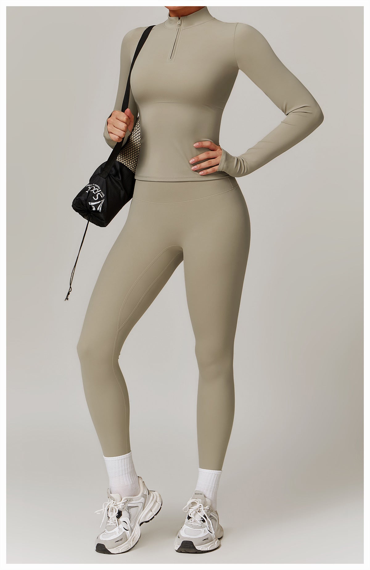 Beige long-sleeved langry athletic bodysuit with white sneakers and black handbag