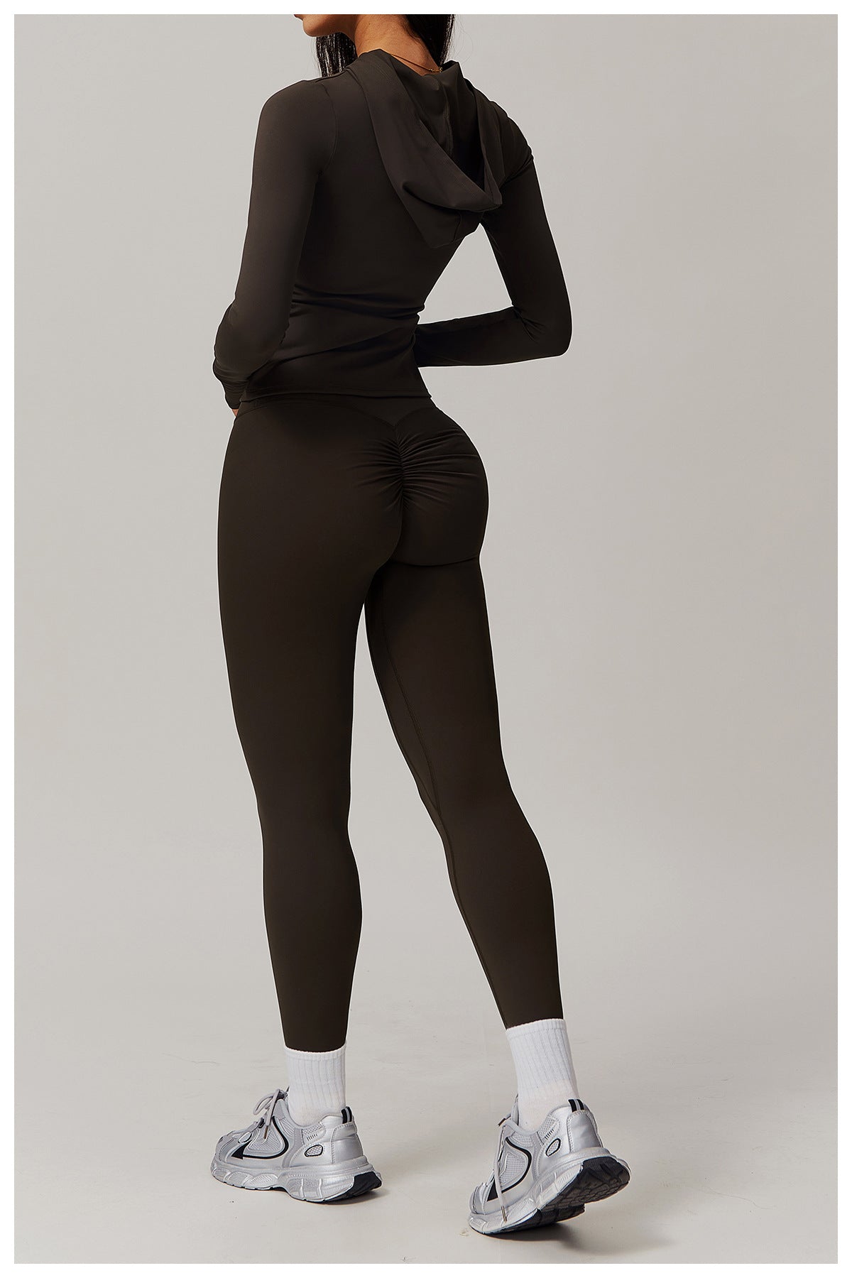 Black athletic bodysuit with long sleeves, white socks, and sneakers for fashion enthusiasts