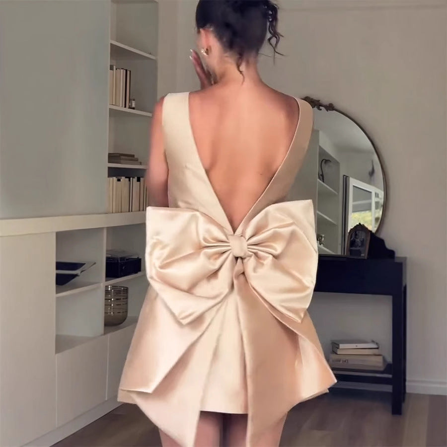 Cream-colored backless dress with oversized bow, ideal for fashionable occasions in ملابس