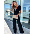 Woman in black jumpsuit showcasing trendy Casual One Piece Trousers for stylish fashion ملابس