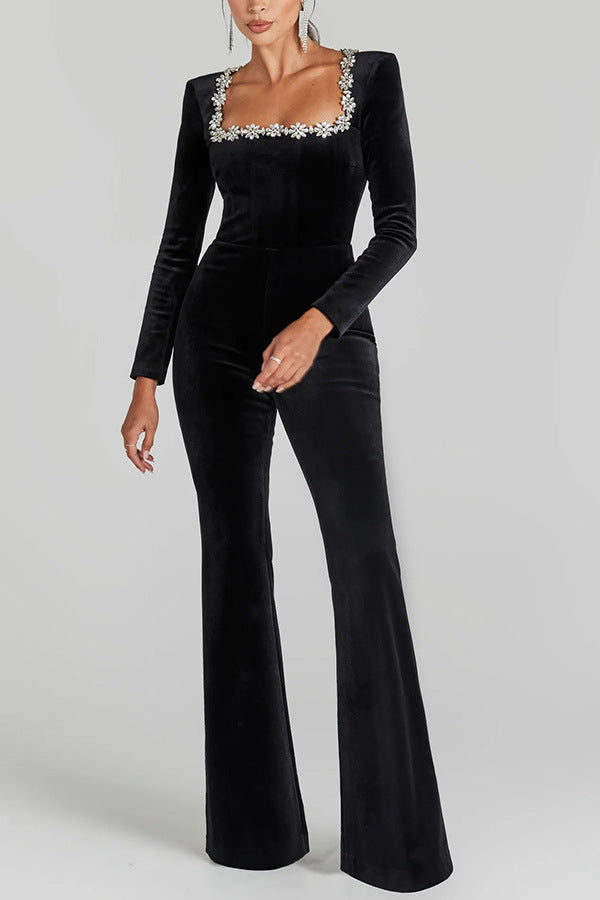 Black velvet jumpsuit with flared legs, long sleeves, and crystal neckline for fashion