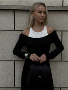 Stylish black and white cold-shoulder dress with a handbag, perfect for fashion enthusiasts