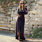 Long black maxi dress with side slit and long sleeves, perfect for stylish fashion attire