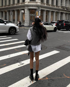 Woman in white shirt dress and gray sweater showcases Langry fashion on city street