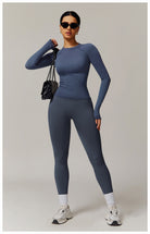 Woman in blue long sleeve athletic wear styled with a black purse, showcasing fashionable langry