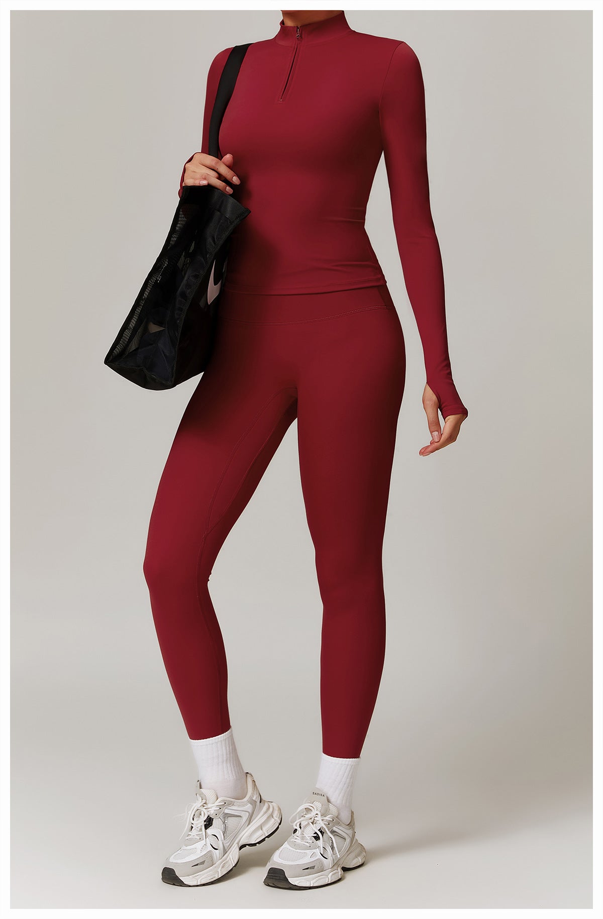 Burgundy langry turtleneck jumpsuit with sneakers and a black handbag for fitness fashion