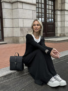 Black knit maxi dress with white sneakers and a black backpack for stylish fashion ملابس