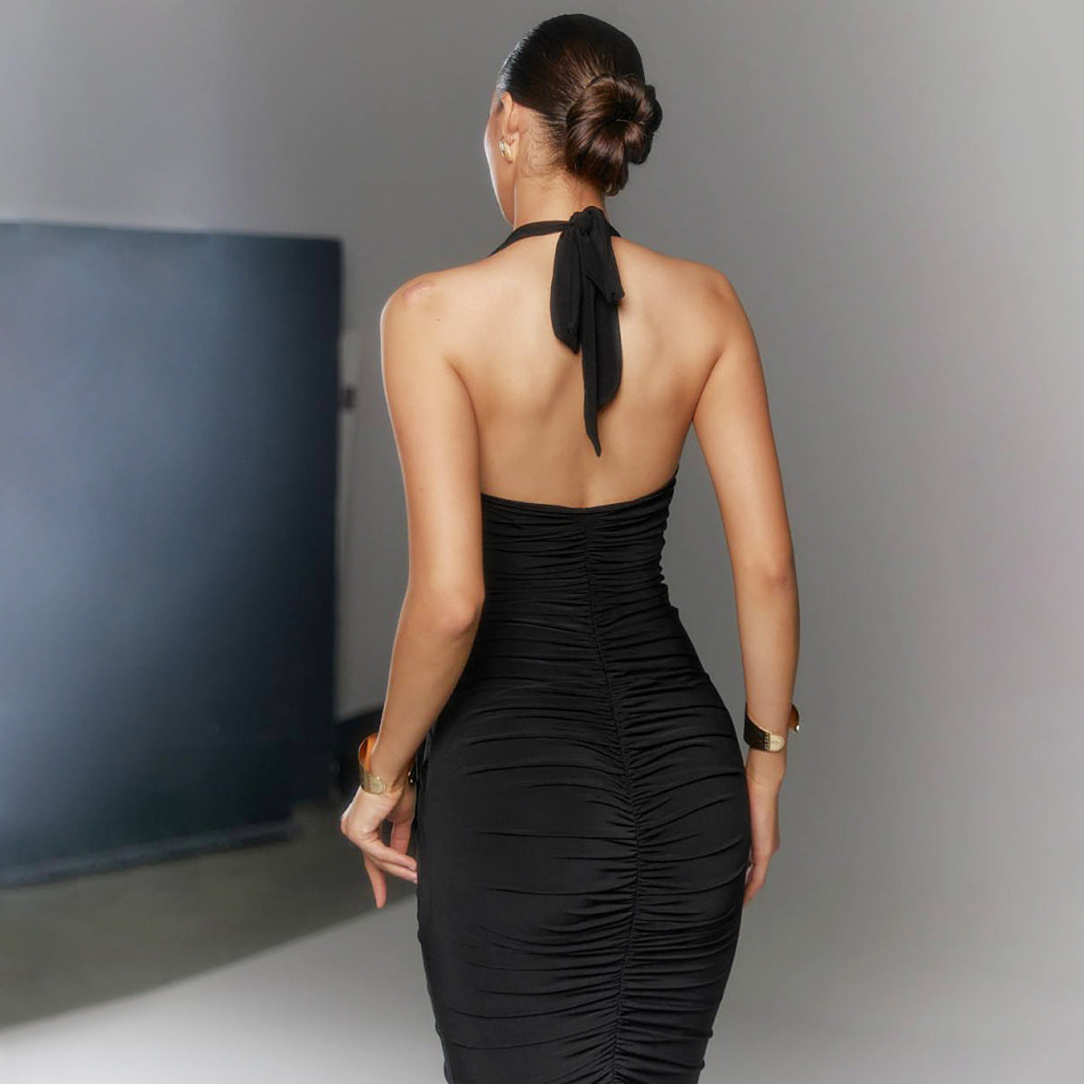 Black ruched halter dress with a fitted silhouette in elegant fashion style