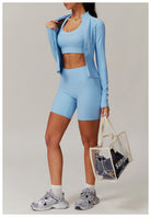 Light blue langry workout set with cropped jacket, sports bra, and biker shorts