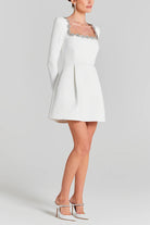 White long-sleeved mini dress with embellished neckline, perfect for elegant fashion ملابس