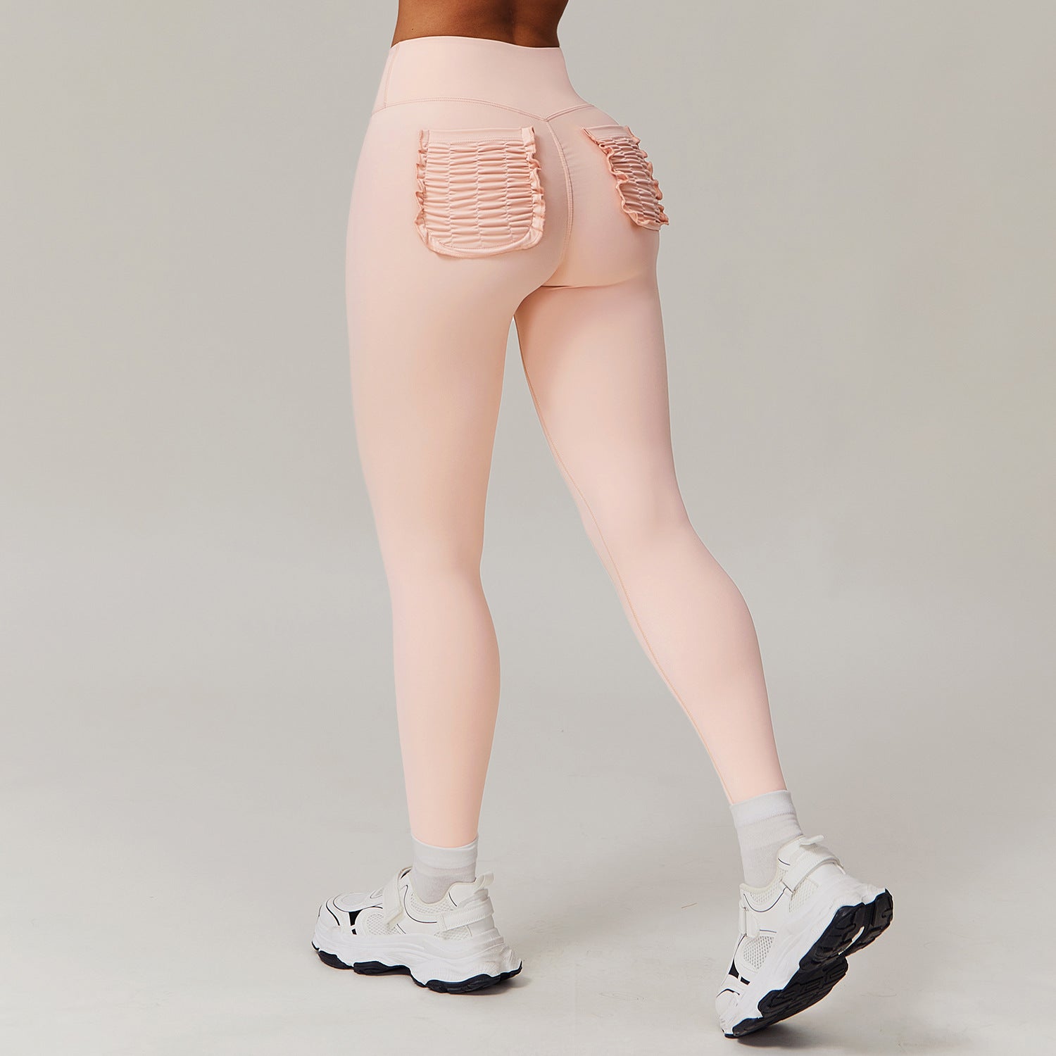 Peach-colored leggings with ruffled back pockets for stylish casual sports fashion