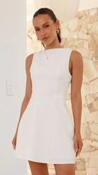 Sleeveless white A-line dress showcasing elegant turtleneck backless design in fashion ملابس