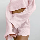 Pale pink textured loungewear set with a cropped top and shorts.