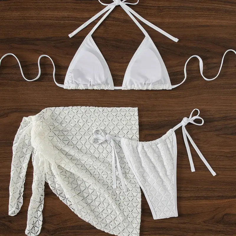 White bikini set with a matching lace cover-up skirt.