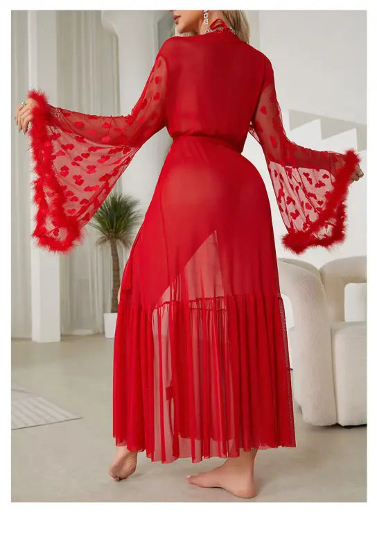 Red sheer dress with bell sleeves and a feathered trim.