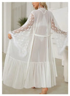 Flowing white sheer robe with polka dot sleeves and a ruffled hem.