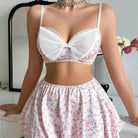 Two-piece floral outfit consisting of a white bra top and matching skirt with pink flower pattern.