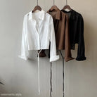 Three button-up shirts in white, brown, and black complementing Comfy Sunrise Cardigan