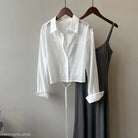 Cropped white button-down shirt with long sleeves on a hanger for Sunrise Cardigan set