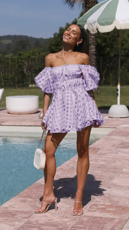 Off-the-shoulder lavender mini dress with puff sleeves and a checkered pattern.