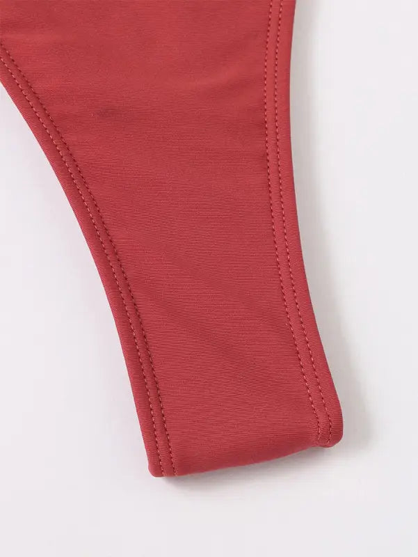 Red fabric strap with stitched edges.