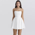 White strapless mini dress with a fitted bodice and flared skirt.