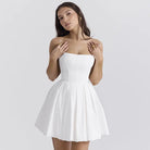 White strapless mini dress with a pleated skirt.