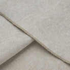 Beige linen or cotton fabric with visible texture and seams.