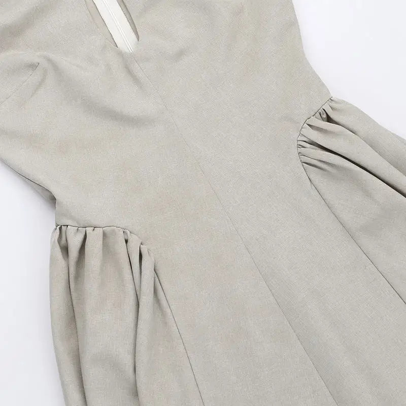 Light gray dress with gathered fabric details at the sides.