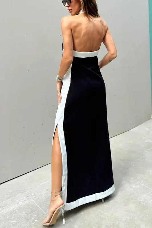 Long black and white backless evening gown with a side slit.