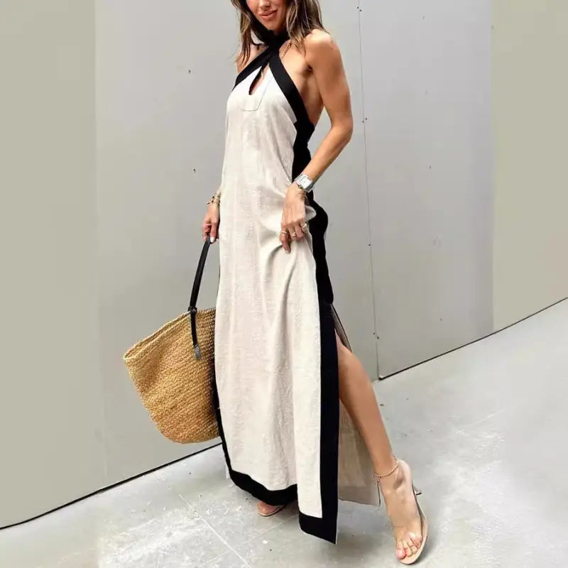 Long white halter dress with black trim and side slit.