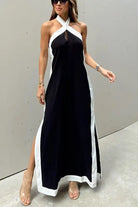 Long black halter dress with white trim and side slits.