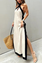 Long halter-neck maxi dress with contrasting black trim and side slit.