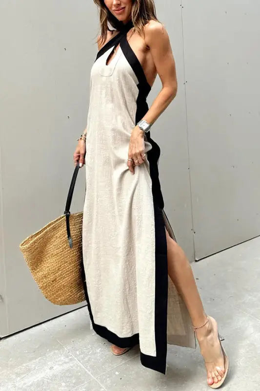 Long halter-neck maxi dress with contrasting black trim and side slit.