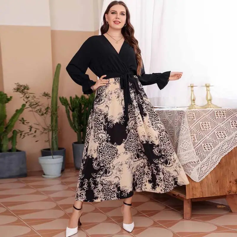 Long dress with a black top and patterned skirt worn by a woman posing in an interior setting.