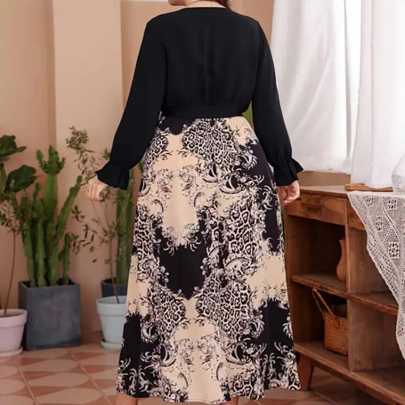 Long dress with a black top and patterned skirt featuring a black and beige floral or abstract design.