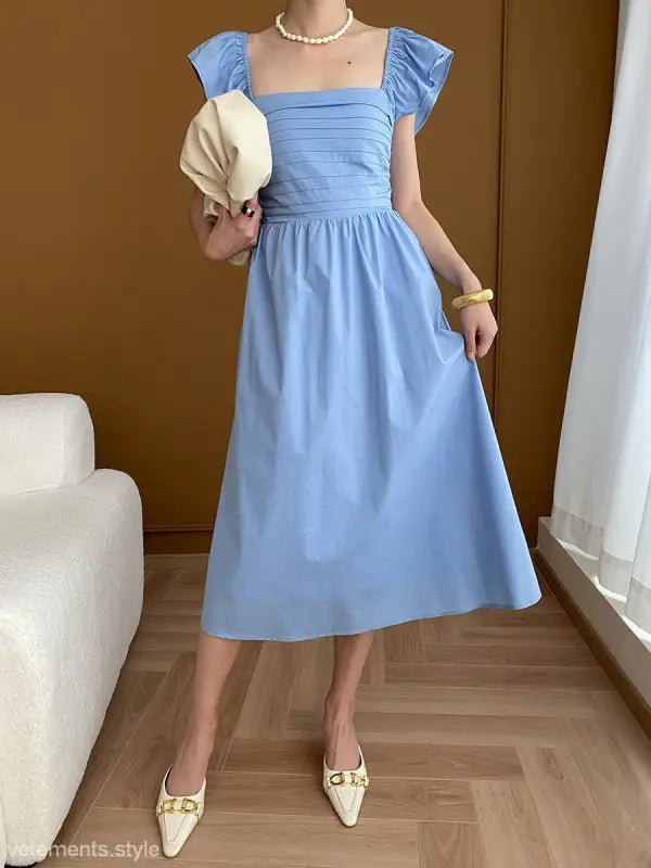 Light blue midi dress styled with the Elegant Flying Dress featuring black ruffled details