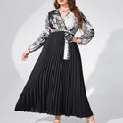 Long-sleeved maxi dress with a black pleated skirt and a black and white patterned bodice.