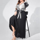 Long black and white patterned wrap dress with a pleated skirt and tie waist.