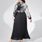 Long black pleated dress with a contrasting black and white patterned top half.