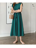 Sleeveless emerald green midi dress with a gathered waist and flowy skirt.