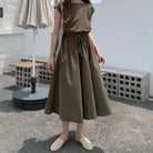 Olive green midi dress with a cinched waist and flowy skirt.