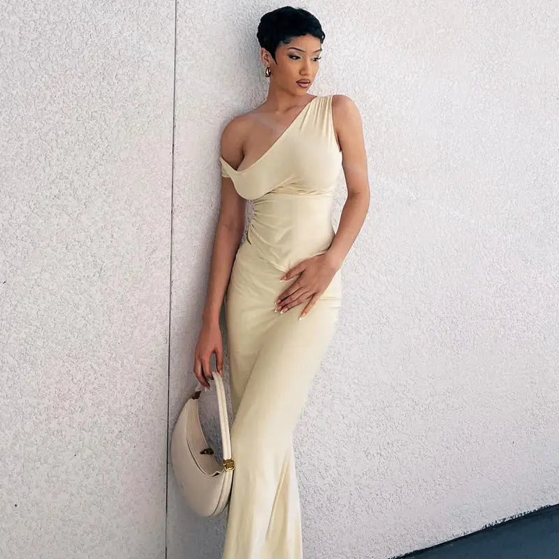 Elegant one-shoulder cream-colored evening gown worn by a woman.