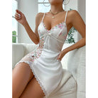 White satin slip dress with floral embroidery and lace trim.